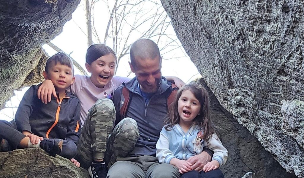 The Bicksler Family - Derek Bicksler with his kids sitting on large boulders and laughing together at whiskey springs hiking area in boiing springs-2