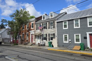 streetscape of historic townhomes in Carlisle, PA 17013 near corner of S Bedford St and E Chapel Ave - blue skies in spring 2026