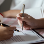 article banner image for 5 Home Listing Documents Every Carlisle Home Seller Must Know: Complete Guide to The Five Most Common Forms, Notices, and Contracts of 2 hands signing a document