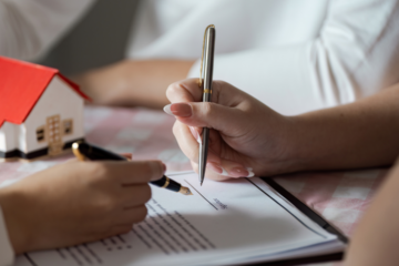 article banner image for 5 Home Listing Documents Every Carlisle Home Seller Must Know: Complete Guide to The Five Most Common Forms, Notices, and Contracts of 2 hands signing a document